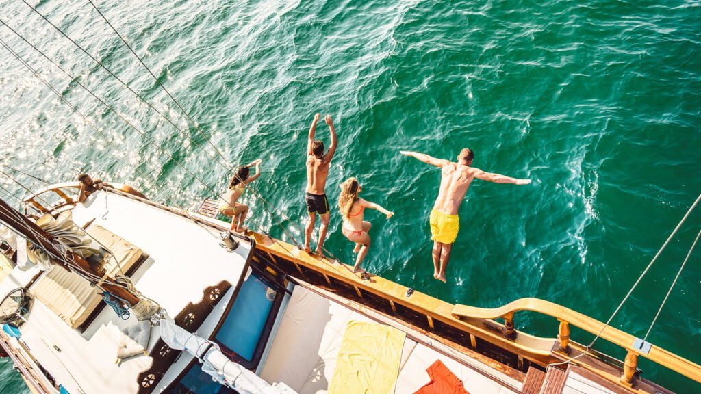 top view trendy adventurous friends jumping from sailboat sea ocean trip 1